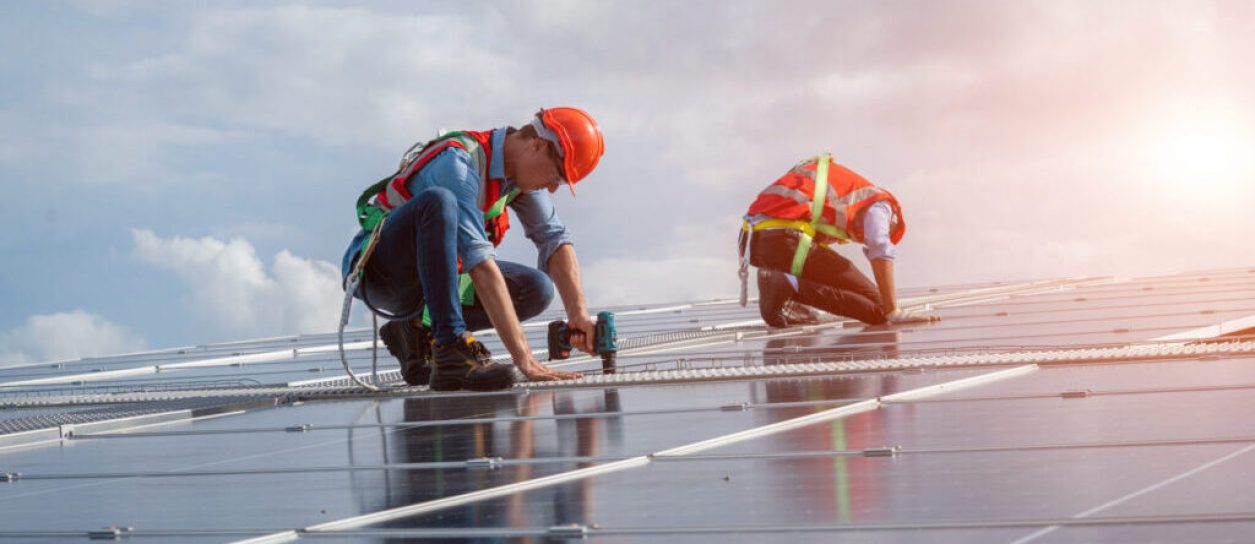 Techniker verwendet Bohrmaschine während der Installation der Solarmodule. photovoltaik elektriker