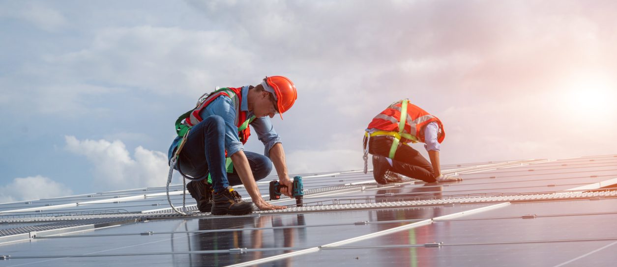 Technician uses drilling machine during the installation of the solar modules. photovoltaic electrician